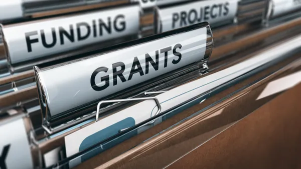 Hanging files with tabs that say "GRANTS," "FUNDING," "PROJECTS"