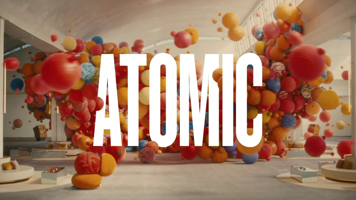 A group of multicolored balls in a room with the word Atomic in the foreground.