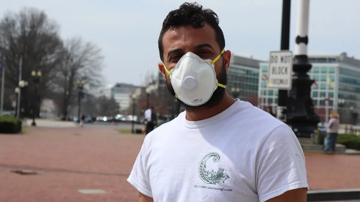 Man in face mask in front of Union Station at 50 Massachusetts Avenue, NE, Washington DC