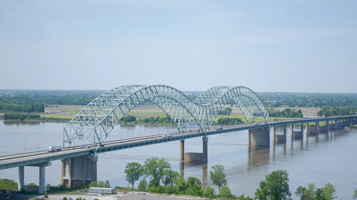 The silver hernando de soto bridge spans a river.