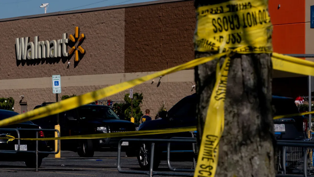 Crime scene tape wrapped around a tree in front of a Walmart store.