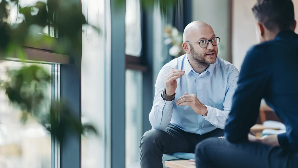 Man sitting and talking to another man