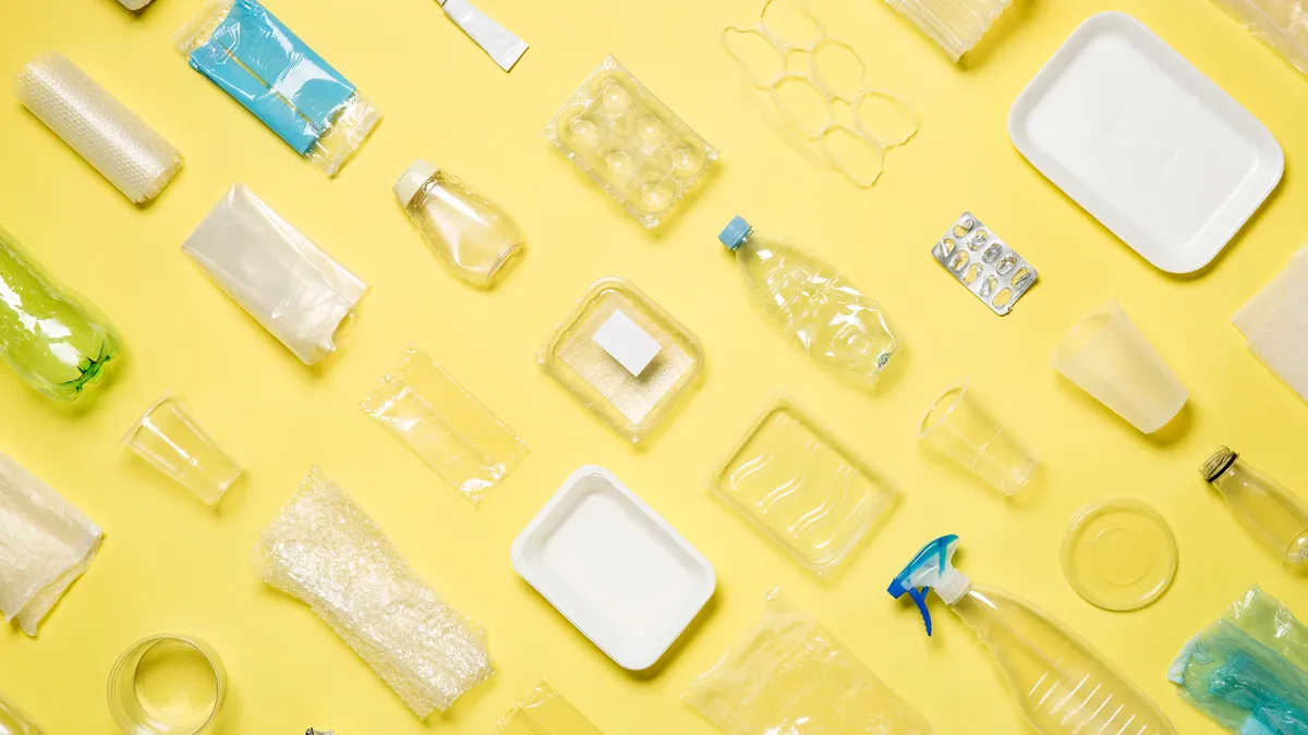 Mixed plastic packaging laid out against a yellow backgruond