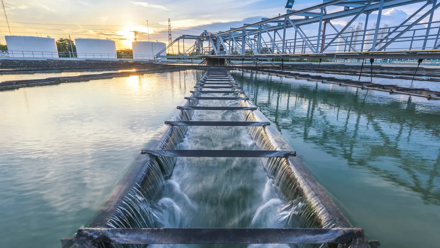 Water treatment plant infrastructure at sunset.