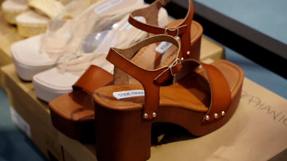 Two pairs of shoes are pictured up close in a store display.