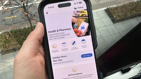 Close-up of a person holding a phone with the Kroger app open.