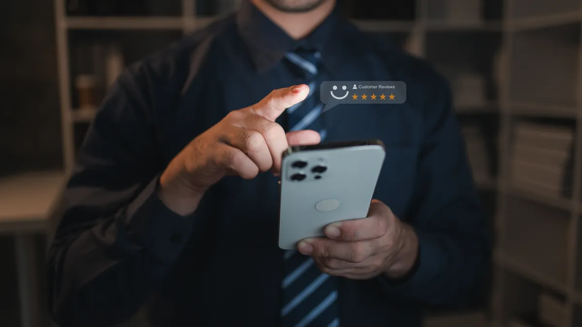 A person holds a smartphone with a product review icon on a website page.