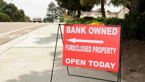 Image of a directional sign pointing to a foreclosed home