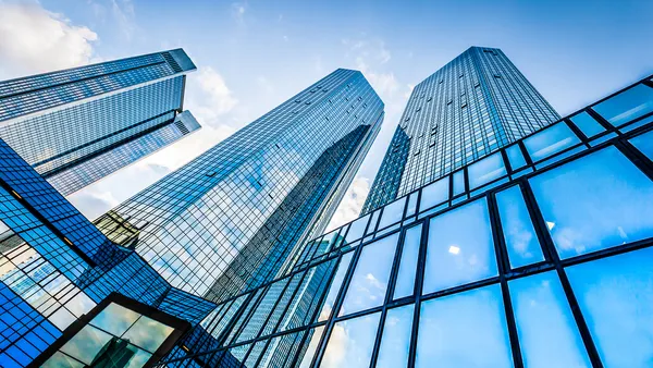 Bottom view of modern skyscrapers in business district against blue sky.