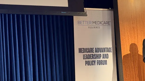 The Better Medicare Alliance's logo is shown against a blue curtain.