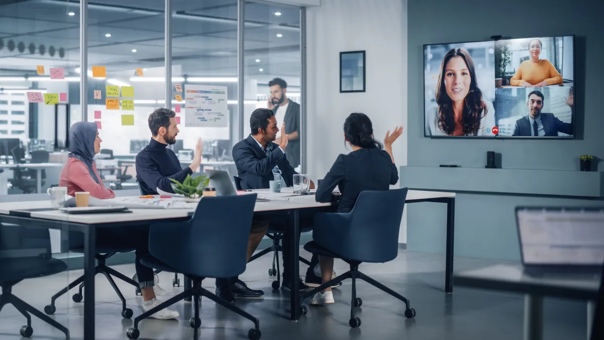 Business people have Video Conference Call with Big Wall TV in Office Meeting Room