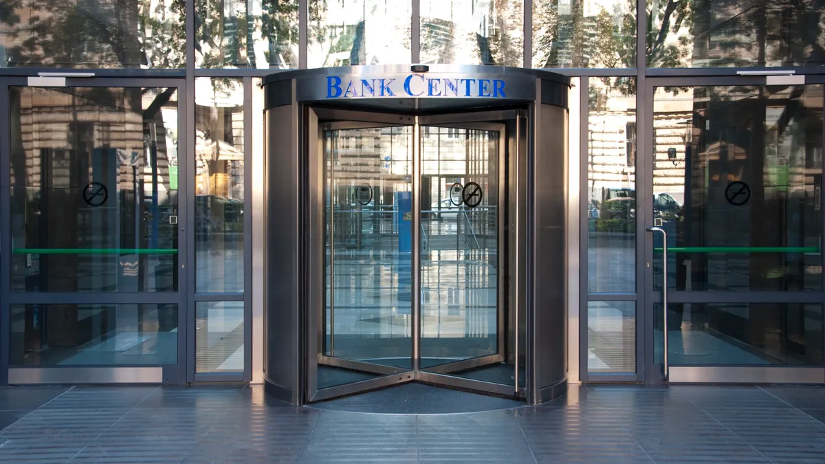 The entrance to a bank center with revolving doors is pictured.