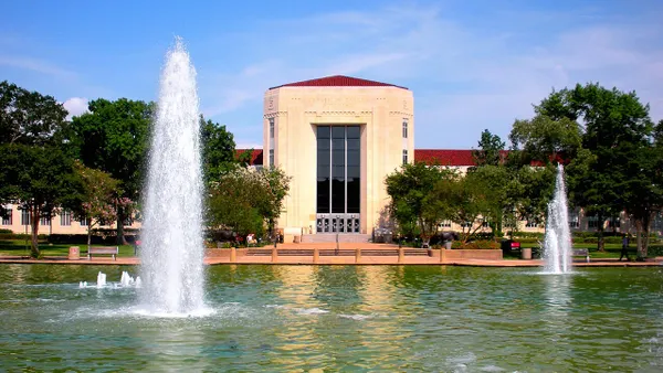 White stone turret framed by fountain on a university campus.