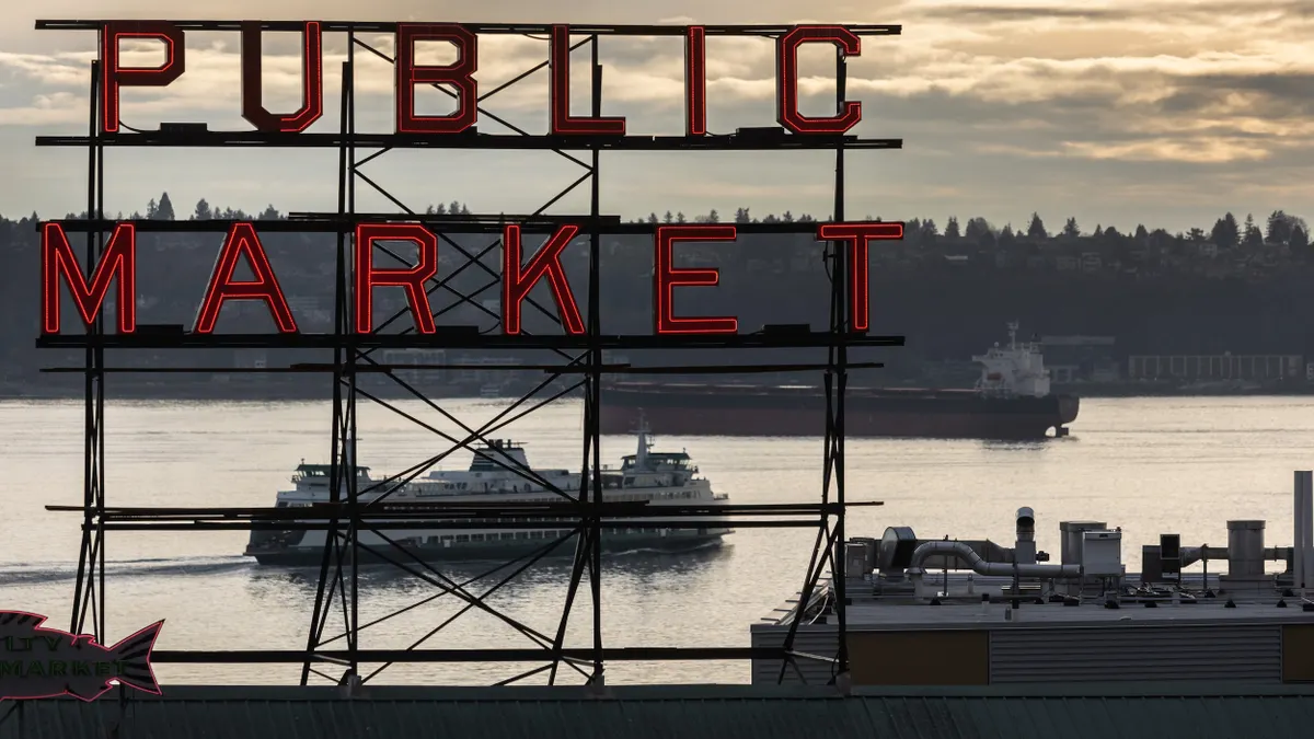 A view of a large ferry boat seen through a sign that reads "Public Market."