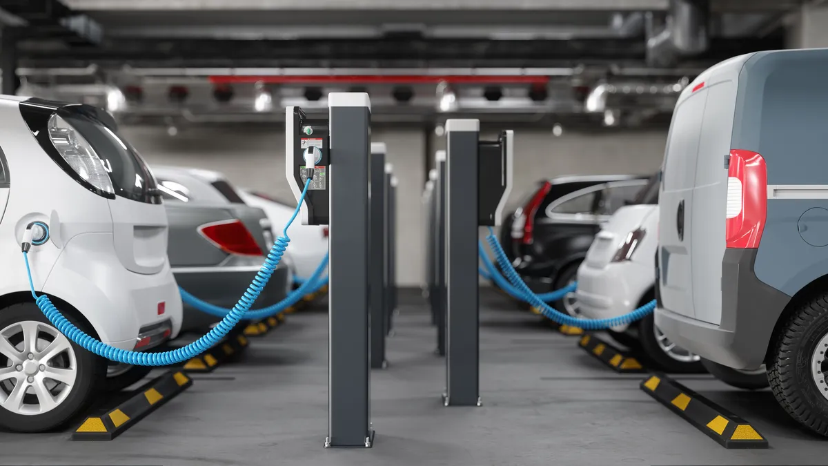 A row of electric vehicles charging in a parking garage.