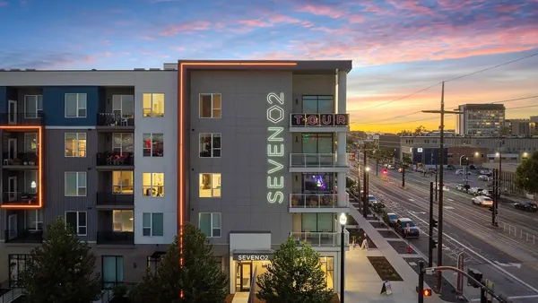 Four-story modern apartments with streets on either side.