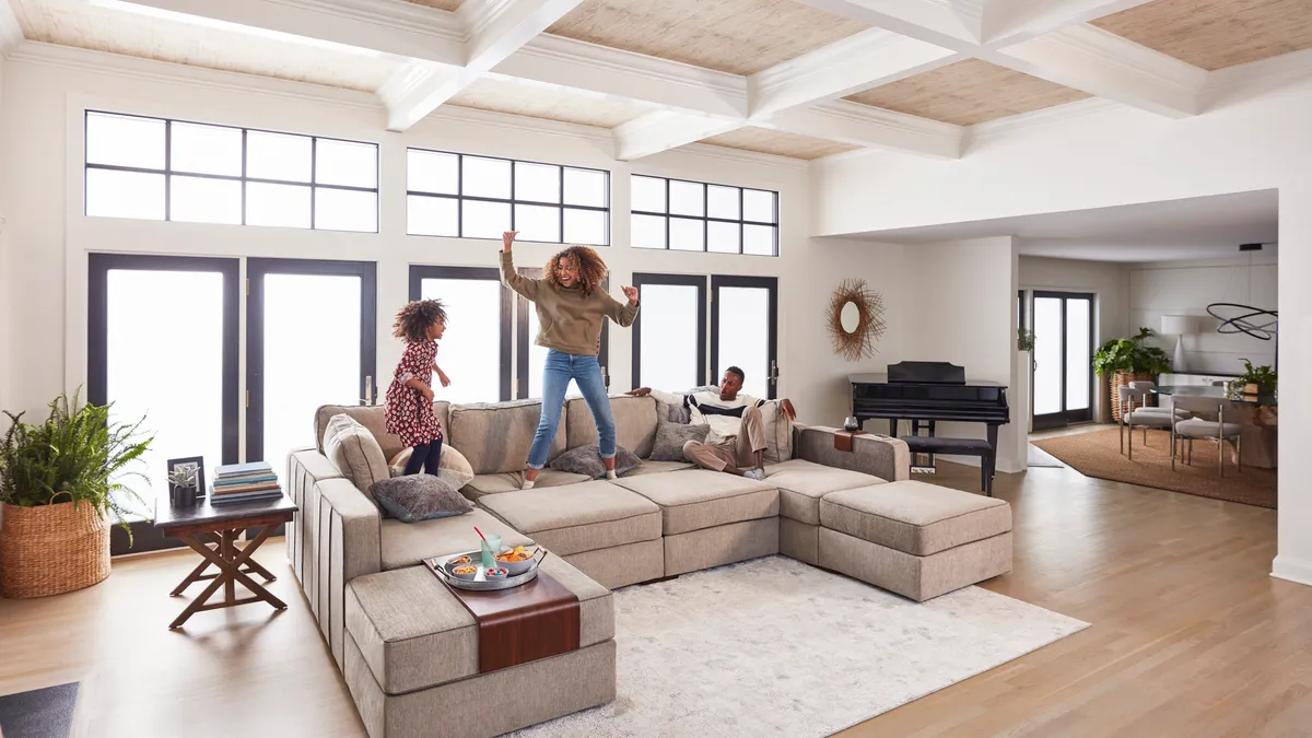 Two girls jumping on a couch