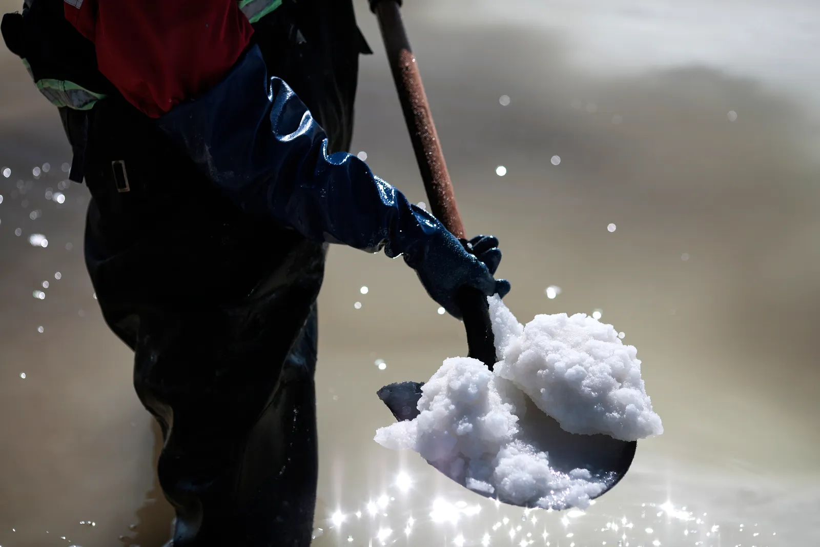 A worker uses a shovel to move the raw material for the manufacture of lithium carbonate at the Llipi pilot Planton August 14, 2022 in Uyuni, Bolivia.