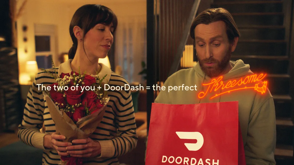 A couple receives a package from DoorDash for Valentine's Day in the platform's "Threesome" campaign.