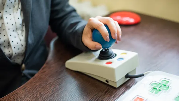 Woman with cerebral palsy works on a specialized computer mouse