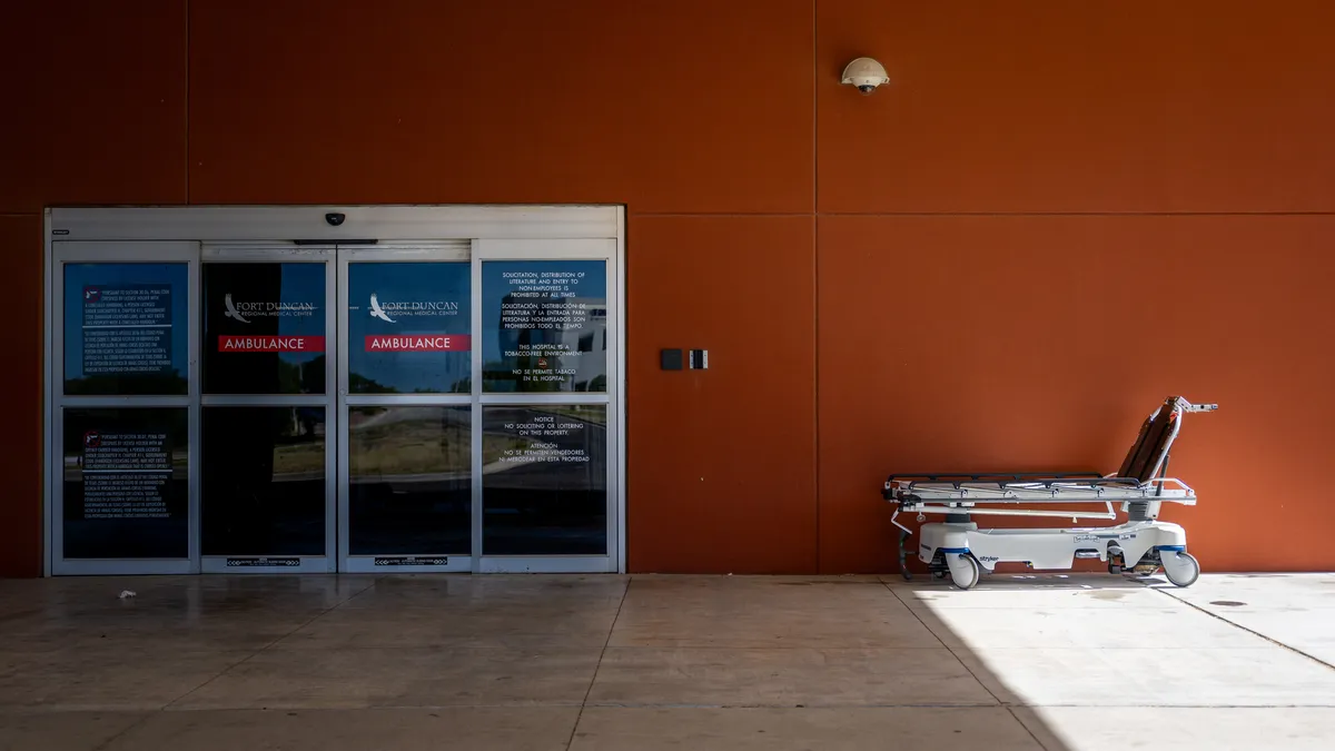 Rolling hospital bed sits outside emergency room entrance at hospital