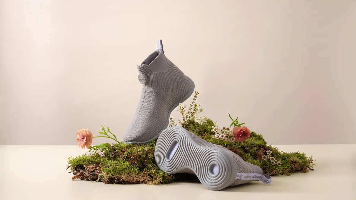 A display of grey Allbirds Moonshot shoes with colorful flowers