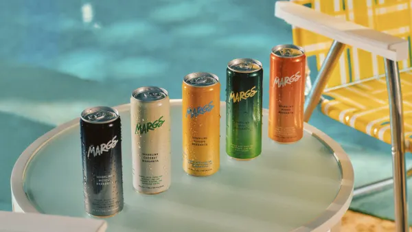 Five cans of Sipmargs are pictured next to each other on a table next to a pool.