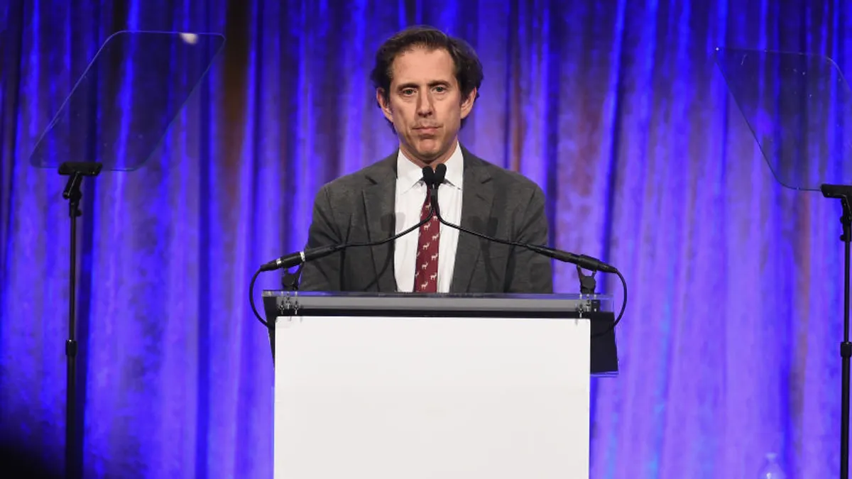 A person speaking at a podium.