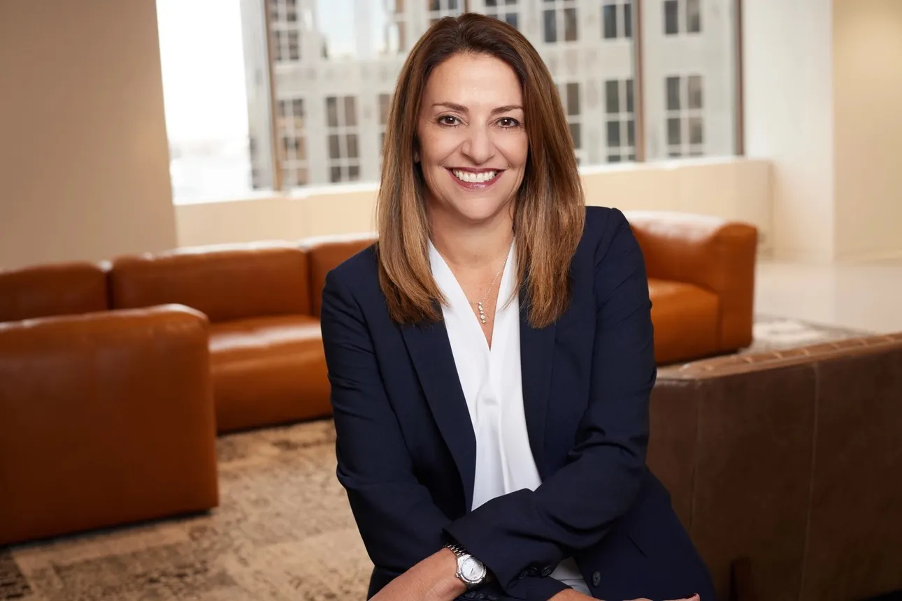 A photo showing a person in an office from the waist up.