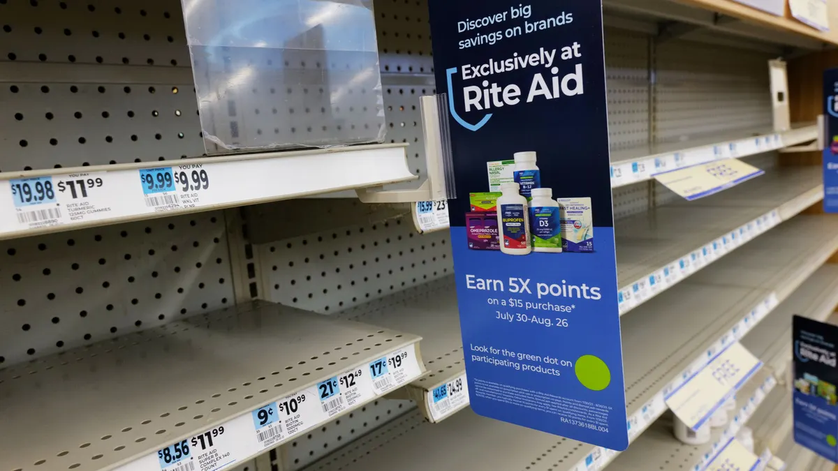 Empty shelves inside a Rite Aid store in New York City on Aug. 28, 2023. A sign on the shelves reads: "Discover big savings on brands exclusively at Rite Aid. Earn 5X points on a $15 purchase July 30-Aug. 26. Look or the green dot on participating products."