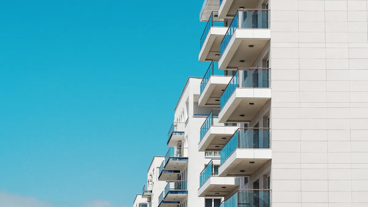 The exterior of a white hotel building with balconies.