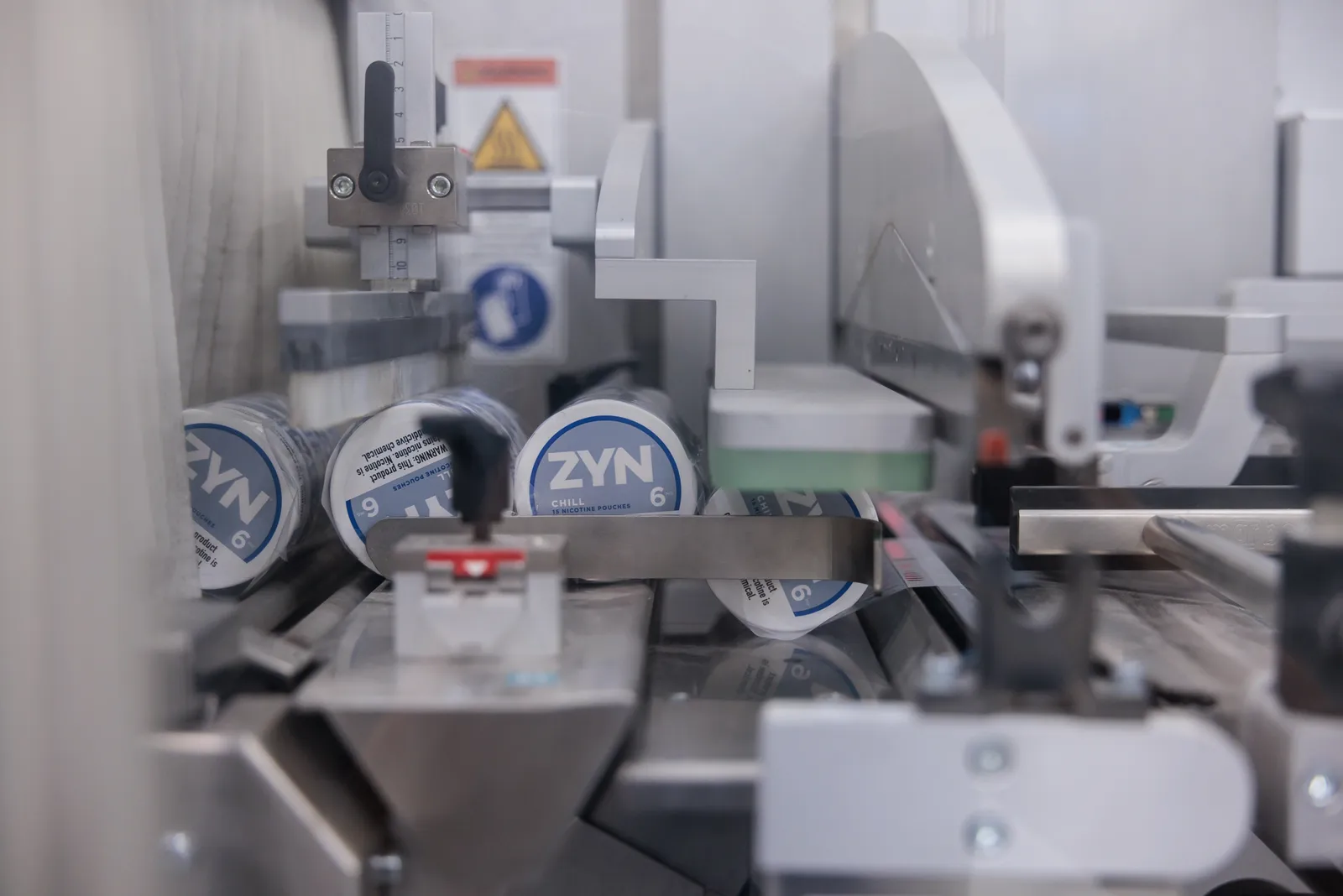 An image of a factory, processing hockey puck sized canisters that read &quot;Zyn chill.&quot;