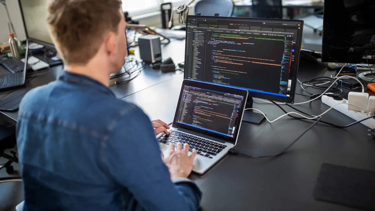 A software developer writes code at his desk