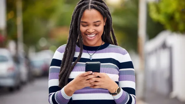 Woman smiling and using phone