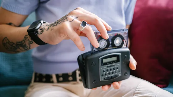 Tattooed person listening to cassette tapes with Walkman