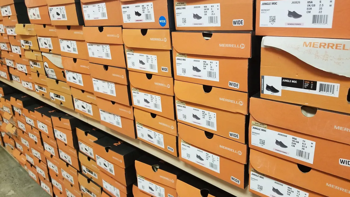 Boxes of Merrell shoes are stacked inside a store.