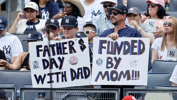 New York Yankee fans hold banners in reference to Father's Day