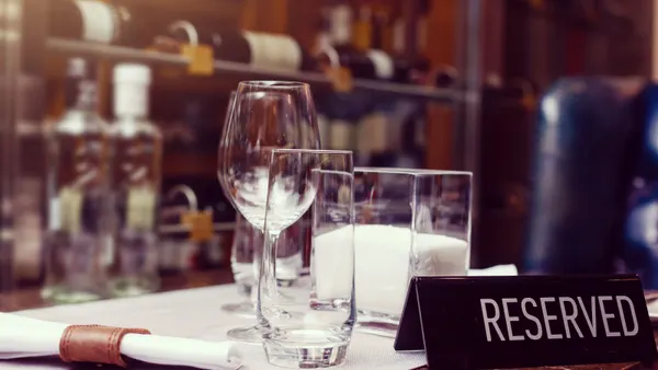 An image of a table setting in a restuarnat with a black reserved sign on the right foreground