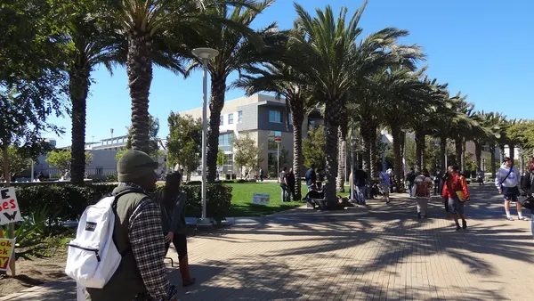 Students walking on wide path in sunny California weather.