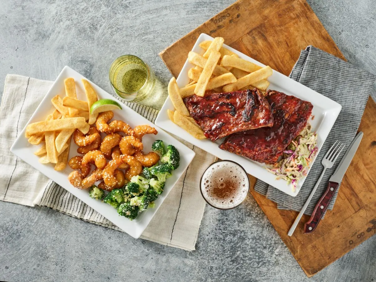 Red Robin menu items, including shrimp, fries and rigs atop white plates.