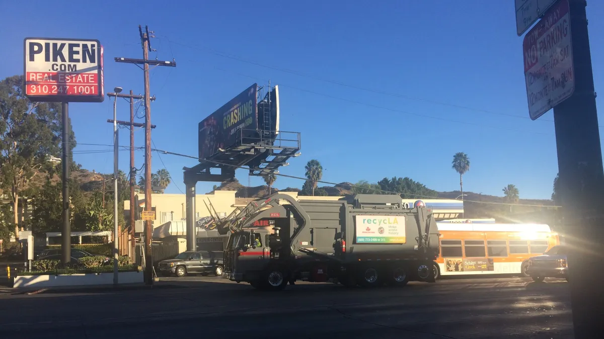 Trash truck with recycLA logo driving in Los Angeles