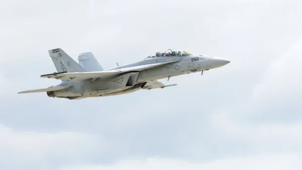 A gray fighter jet flying in the sky.