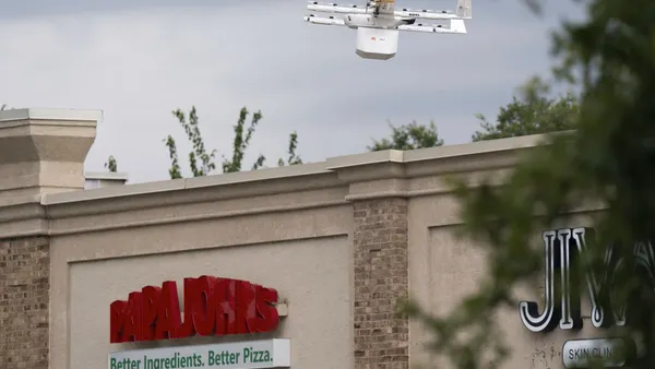 A Wing drone over a Papa Johns.