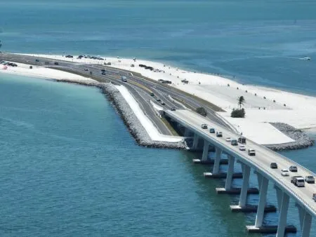 An aerial view of a bridge with several cars crossing it.