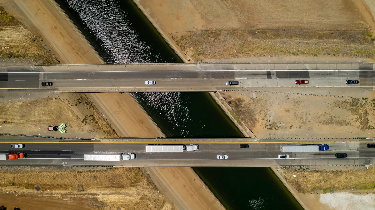 An overhead view showing passenger and commercial traffic on bridges over the California Aqueduct in the heart of the Central Valley.
