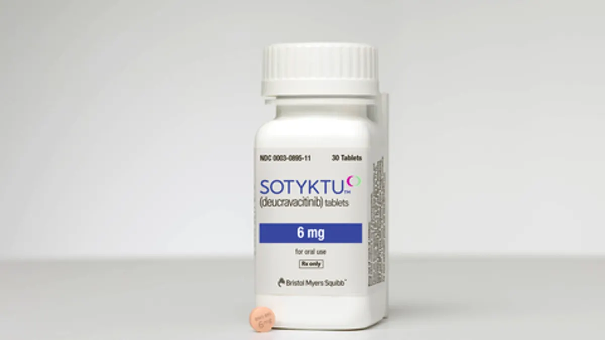 An image of a pill bottle next to a tablet of Sotyktu, a psoriasis medicine from Bristol Myers Squibb.