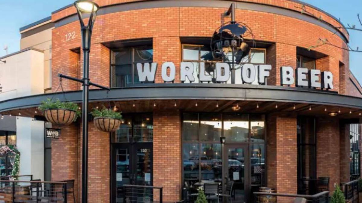 An oval shaped brick facade with a "world of beer" signage in metal gray.