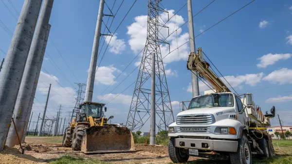 Construction equipment is stationed near transmission towers