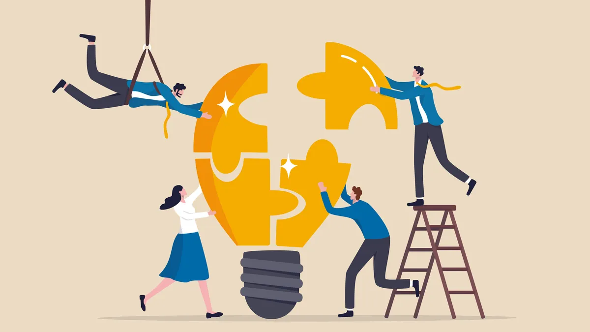 Businessmen and businesswomen team up to solve lightbulb jigsaw.