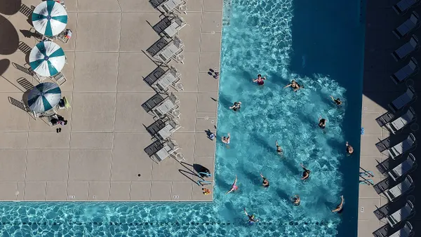 Overhead image of people swimming in a pool at a housing development.